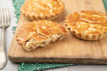 Homemade chicken stuffed pies over wooden board