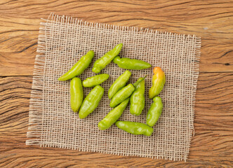 Green cheiro peppers on a rustic fabric over wooden table. Typical brazilian ingredient