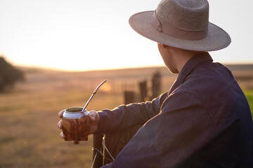 Gaúcho segurando chimarrão pôr do sol no pampa