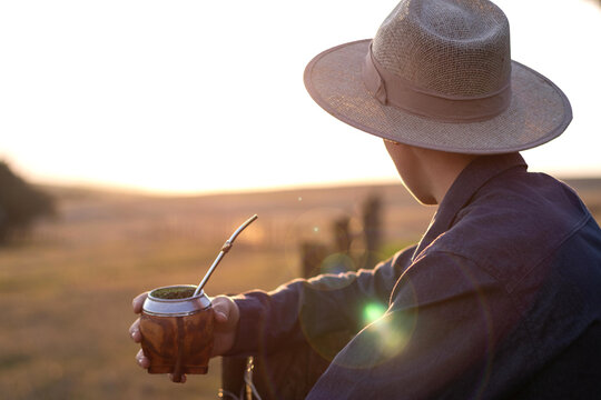 Ga&uacute;cho segurando chimarr&atilde;o p&ocirc;r do sol no pampa