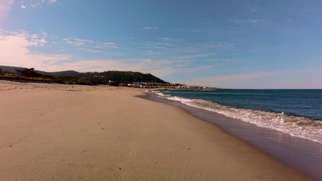 Ocean beach with calm waves. Summer vacation background. Village on the seacoast. Beautiful nature landscape. Portugal. Caminha. Moledo