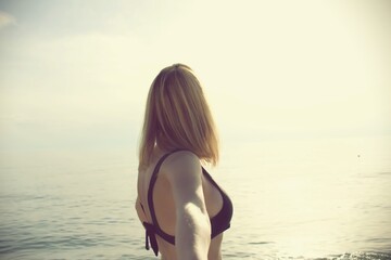 Sexy woman with bathing suit asking to follow her at the beach.