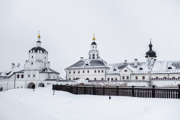 Panorama of buildings of Sviyazhsky Uspensky Monastery in winter. Black roofs and domes contrast with white walls, snow and sky. Complex is located near village of Sviyazhsk near Kazan, Russia