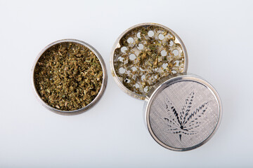 Metallic hemp grinder with cannabis in it.