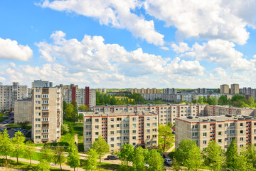 Fototapeta premium Aerial panoramic view of the southern part of Siauliai city in Lithuania.Old soviet union buildings with green nature around and yards full of cars in a sunny day.