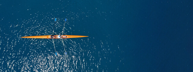 Aerial drone top ultra wide panoramic view of sport canoe rowing synchronous male athletes...