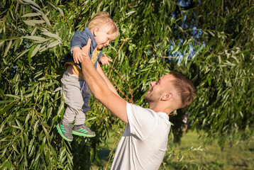 Happy father with his adorable toddler boy son on sunset. . Family having fun and enjoying day in the park. Fatherhood, childhood and lifestyle concept