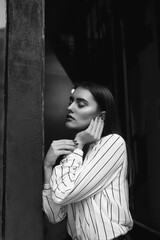 Black and white indoor portrait of an awesome young woman wears striped white shirt
