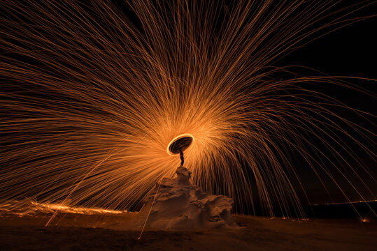 Steel wool photography at the desert rock structure at night time with fire splash all over. Slow Shutter speed photography with steel wool