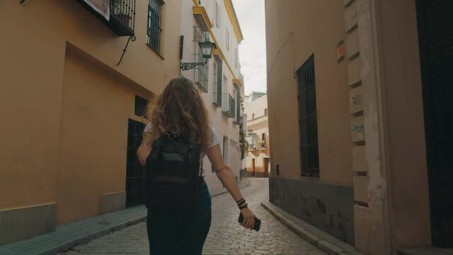 Exchange student explore new city. Young traveller woman walk on narrow street of european town. Millennial wanderlust lifestyle concept. Woman filming her trip on smartphone
