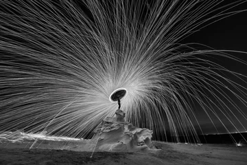 Photo sur Aluminium Noir et blanc Photographie de laine d& 39 acier à la structure rocheuse du désert la nuit avec des éclaboussures de feu partout. Photographie à vitesse d& 39 obturation lente avec de la laine d& 39 acier en noir et blanc