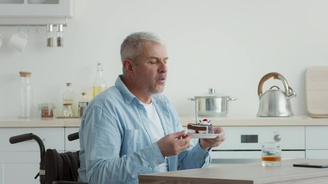 Disabled Senior Male In Wheelchair Celebrating Birthday Alone At Home