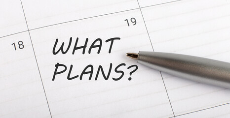 Text WHAT PLANS on calendar planner to remind you an important appointment with a pen on isolated white background.