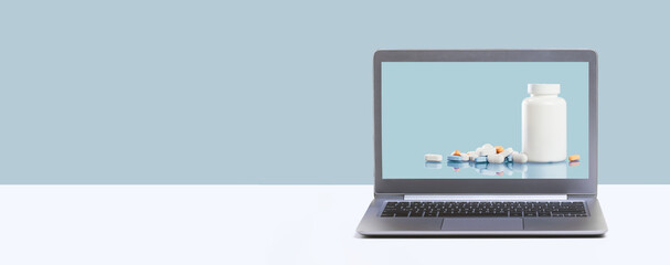 Fototapeta na wymiar Online pharmacy. prescription drugs and over the counter medication ready for delivery to customers. Pills and white mockup jar on laptop screen. Drugstore shopping banner