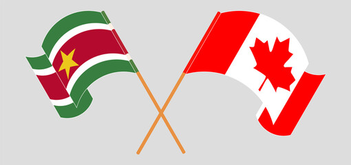 Crossed and waving flags of Suriname and Canada