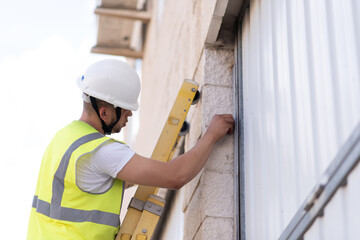 telecommunications technician climbing a ladder working on a wall