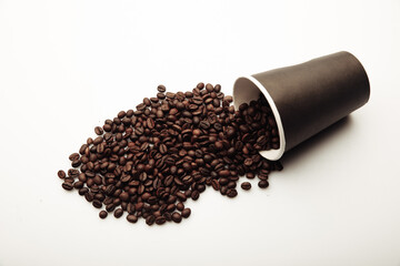 Cup of coffee full of coffee beans on white background