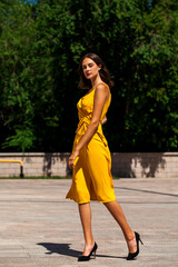 Young brunette woman in yellow dress