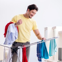 Handsome man husband doing laundering at home