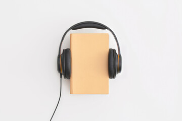 Headphones and books on white background. Flat lay, top view. Concept of audiobook