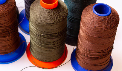 multicolored sewing threads on industrial bobbins