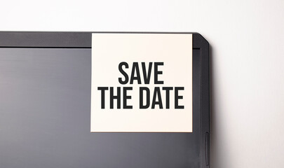 Sticky note on the computer. Text Save the Date