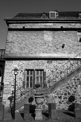 Restaurierte alte Fassade mit Treppenaufgang, Schiefer und Bruchstein im Sommer bei Sonnenschein...