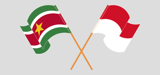 Naklejka premium Crossed and waving flags of Suriname and Indonesia