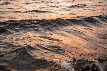 picture of the surface water in the sunset time. The texture of the river water at sunset.
