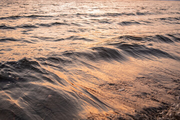 picture of the surface water in the sunset time. The texture of the river water at sunset.