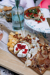 brie cheese with red currant jam. camembert cheese with red jam. cheese plate with prosciutto or dried ham close-up.