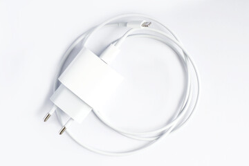 Top view of black phone AC charger and USB cable on white background