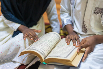 Siblings studying and reciting the Quran 
