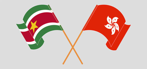 Crossed and waving flags of Suriname and Hong Kong