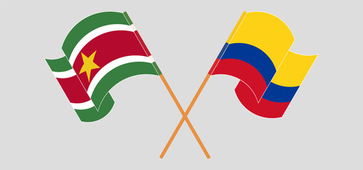 Crossed and waving flags of Suriname and Colombia