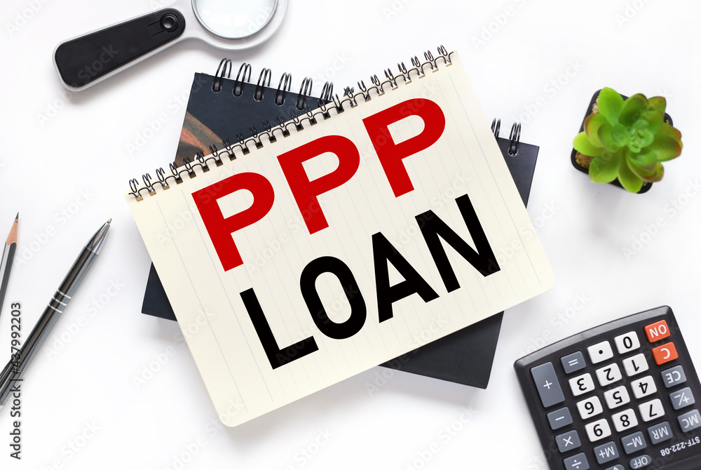 Poster paycheck protection program ppp loan. an open notebook lies on a closed notebook near a calculator a