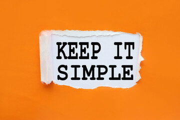 Keep it simple ! text on white paper near torn orange paper