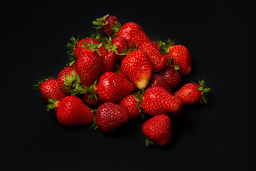A slide of ripe red strawberries on a black background, close up.