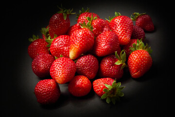 A slide of ripe red strawberries on a black background, close up.