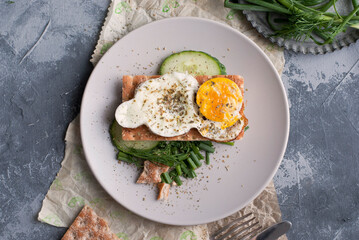 Breakfast sandwich with fried egg, gray background