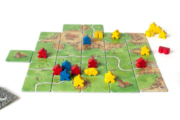 Board game with tiles and small, colorful figures.