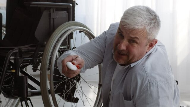 Disabled Senior Man Lying On Floor Pushing Emergency Button Indoor