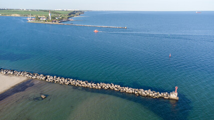 A breakwater made of white concrete cubes and a leading sign at the entrance to the port of Yuzhny....