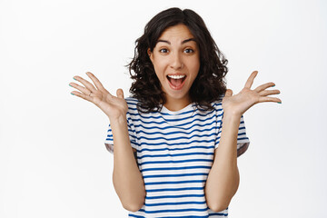 Image of excited screaming young woman standing isolated over yellow background. Looking camera
