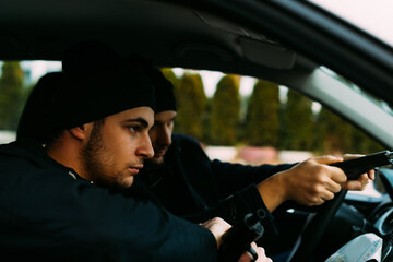 Thieves parked in an ally waiting and planning the way they will rob their target.