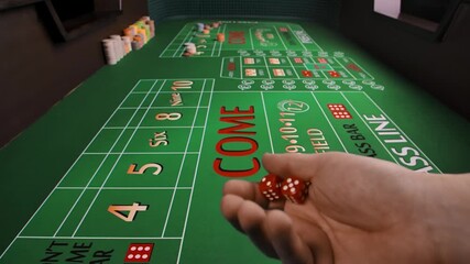 A male hand throws dice on a green craps table in a casino. Close up of a gaming table with placed chips. The concept of gambling business. Slow motion.
