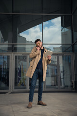 Fototapeta premium Talking on the phone in front of his company