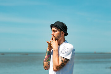 Sochi, Russia, 05.03.2021 a young stylish male yogi with tattoos stands on a sadhu board with nails