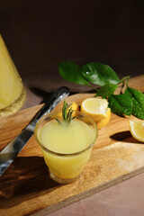 Italian alcoholic lemon drink limoncello. Shot glass of limoncello liqueur decorated rosemary.