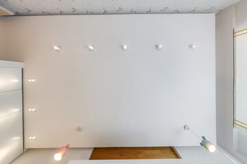 suspended ceiling with led diode spots lamps and drywall construction in empty room in apartment or...